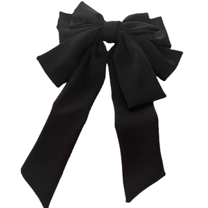 Elegant multi-layered black satin hair bow clip with long streamers on a white background