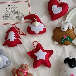 Detailed view of handmade felt Christmas ornaments with embroidery and red hanging loops