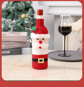 Knitted Santa Clause wine bottle cover on a marble table with a festive background