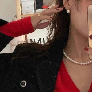 Close-up of French vintage pearl necklace and earrings set worn by a model in a mirror selfie