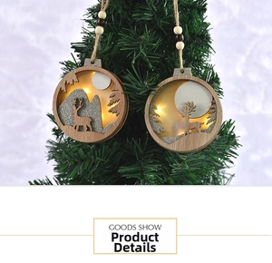Close-up of a lit wooden Christmas reindeer ornament hanging on a pine tree branch