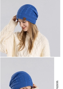 Close-up of royal blue cable knit beanie featuring a mountain sport leather patch detail