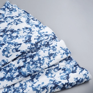 Détail de l'imprimé abstrait bleu et blanc sur tissu soyeux avec coutures de qualité