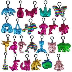 Colorful sequin keychains in animal shapes like unicorn and bear on white background