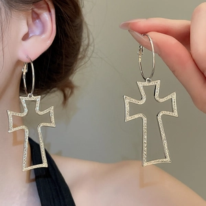 Detail view of silver hollow cross pendant hoop earring with micro-textured finish