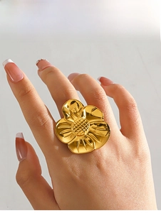 Detailed close-up of a large gold 18K plated stainless steel flower ring on model hand