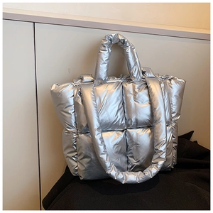 Detail shot of the silver quilted down tote bag with metallic finish and padded shoulder strap