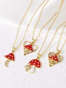 Detailed close-up of red enamel mushroom necklaces with gold plating and sparkling crystals