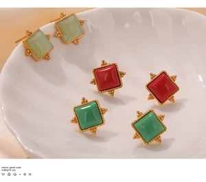 Macro detail of vintage square titanium steel earrings with lace bezel and colored stones