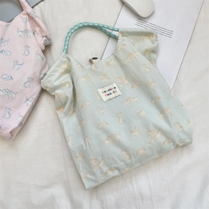 Flat lay of floral canvas tote bags with cat patterns and soft woven rope handles