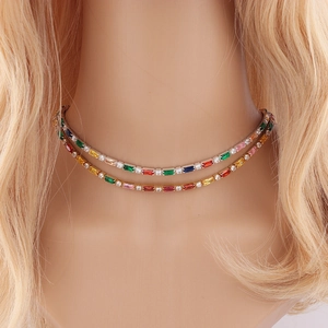 Gros plan sur un collier double couche avec zircons rectangulaires colorés sur le cou