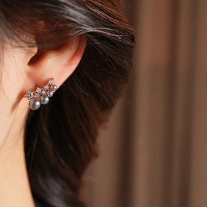 Macro shot of 18k gold plated silver ear climber with grey pearls and cubic zirconia