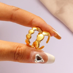 Detailed macro shot of golden adjustable open ring featuring delicate sea shell designs