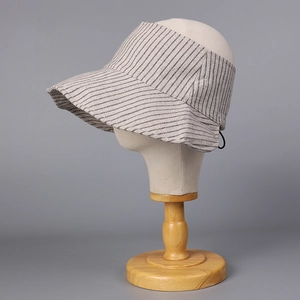 Dettaglio del cappello a visiera a righe in cotone e lino su testa di manichino
