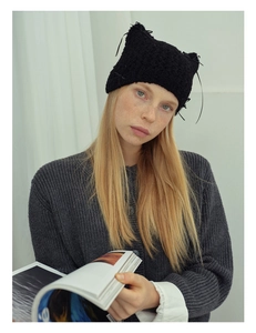 Detailed knit texture of a black cat ear beanie with delicate ribbon bow accents