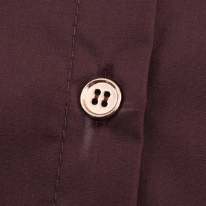 Deep maroon long sleeve top with elegant gold button detail and premium fabric texture