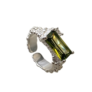 Close-up of 925 sterling silver ring with rectangular green crystal and beaded band texture