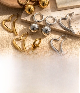 Macro shot of titanium steel heart and bead earrings with premium gold vacuum plating
