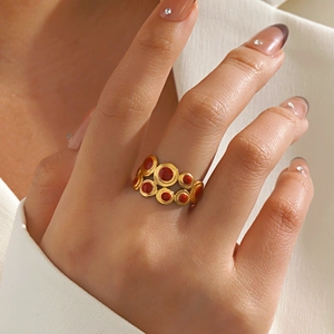 Gold multi-circle geometric ring with red enamel inlay on hand, fashion accessory