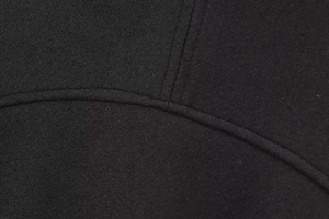 Macro detail of high-quality black wool bomber jacket fabric with precise topstitching