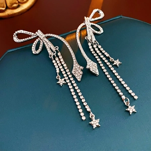 Détails des boucles d'oreilles nœud argenté avec strass, étoiles et longues franges