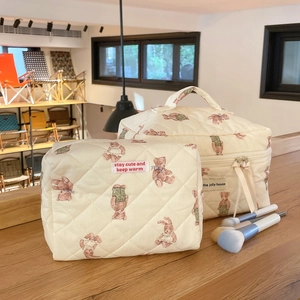 Detailed macro view of quilted cotton cosmetic bags with cute teddy bear pattern prints