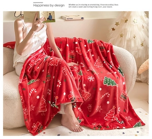Detail of soft red Christmas flannel blanket with festive holiday prints on sofa
