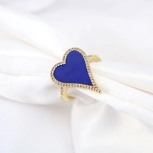 Chic heart-shaped gold ring with blue enamel and micro-paved zircons on silk background