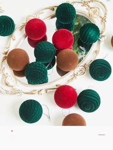 Detailed view of red and green flocked Christmas balls with geometric patterns