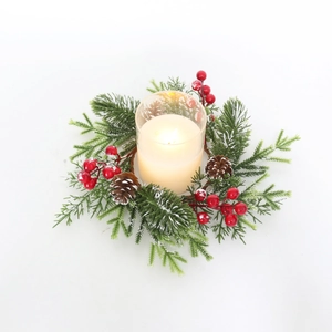 Macro detail of Christmas candle ring with frosted pine needles berries and pinecones