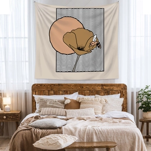 Detail of bohemian wall tapestry with floral and bee design in a cozy bedroom setting