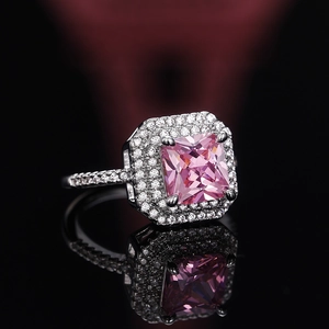Macro detail of luxury princess cut pink zirconia ring with double halo diamond setting