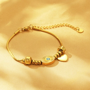 Gold evil eye snake chain necklace with heart pendant on elegant silk background