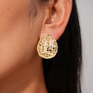 Close-up of model wearing 18k gold plated hollow oval earrings with white zircon accents