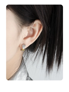 Close-up of S925 silver knot earrings with gold accents and irregular texture