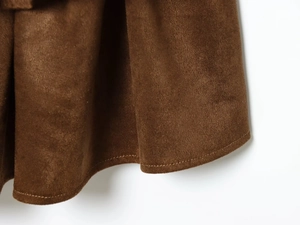 Détail de l'ourlet de robe en daim marron avec coutures à double aiguille de qualité