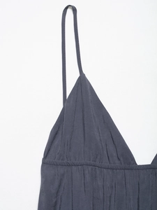 Detail shot of slim spaghetti straps and V-neckline on a dark gray silk-like dress