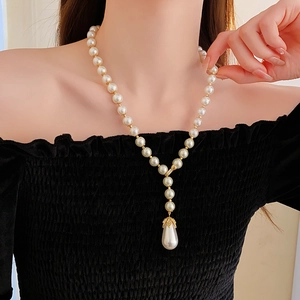 Close-up of elegant Y-shaped pearl necklace with gold fittings and teardrop pearl pendant