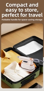 Foldable portable steam iron in white and gold stored inside a green travel suitcase