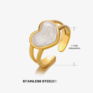 Detailed view of adjustable gold heart ring with white enamel and stainless steel
