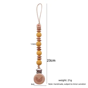 Baby pacifier clip with beech wood and yellow silicone beads featuring a rainbow clip