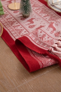 Close-up of red and white Christmas table runner featuring reindeer patterns and tassels