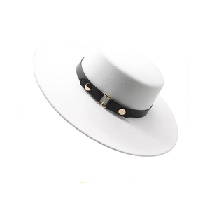 Detail of white wide brim flat top hat with black leather strap and gold buckle accent