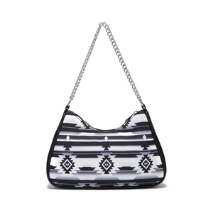 Detail of bohemian Aztec geometric pattern on black and white shoulder bag with chain