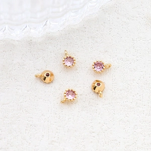 Detailed view of gold plated pink zircon charms and conical pendants for DIY jewelry