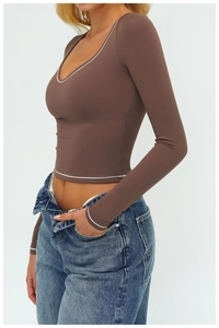 Dettaglio maglia yoga marrone scuro a maniche lunghe con cuciture bianche a contrasto
