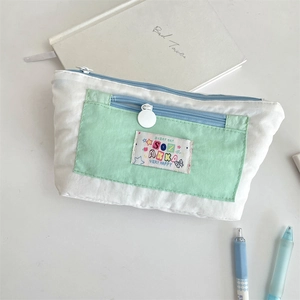 Close-up of mint green canvas pencil case with multi-layer storage and color block design
