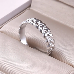 Macro shot of silver stainless steel twisted braided ring on soft satin lining