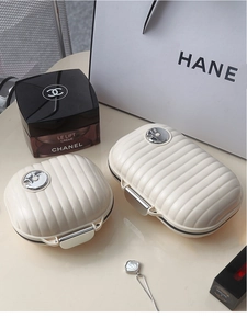 Macro detail of cream suitcase-style pill boxes with premium wavy texture and metal buckle