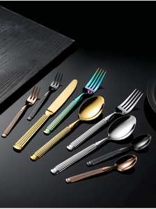 Detail view of colorful stainless steel cutlery with classic striped handles on dark surface